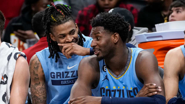 Memphis Grizzlies guard Ja Morant and forward Jaren Jackson Jr. speak on the bench.
